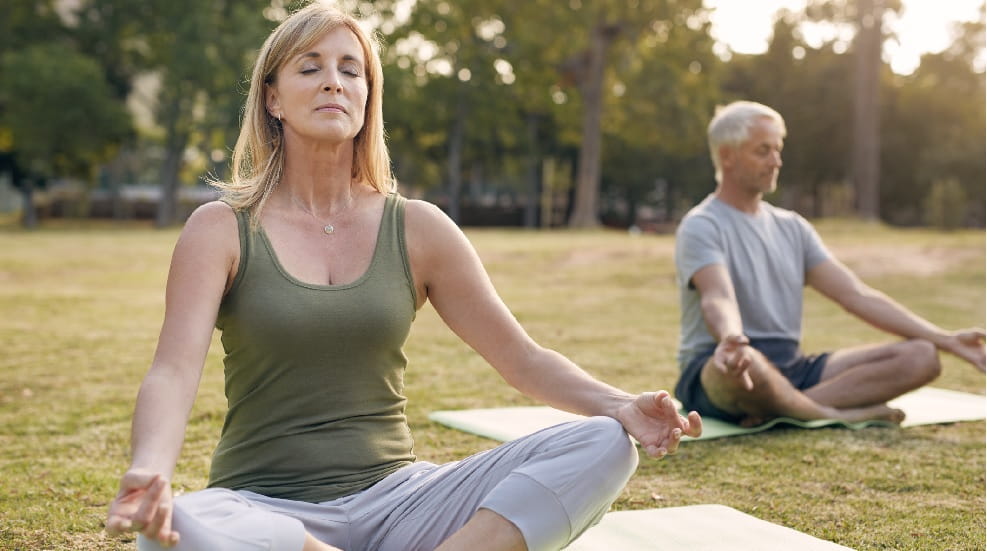 Two people sat in yoga poses